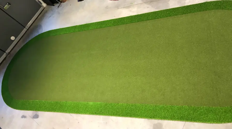 Pitkä ja kapea valmisviheriö hallin lattialla.