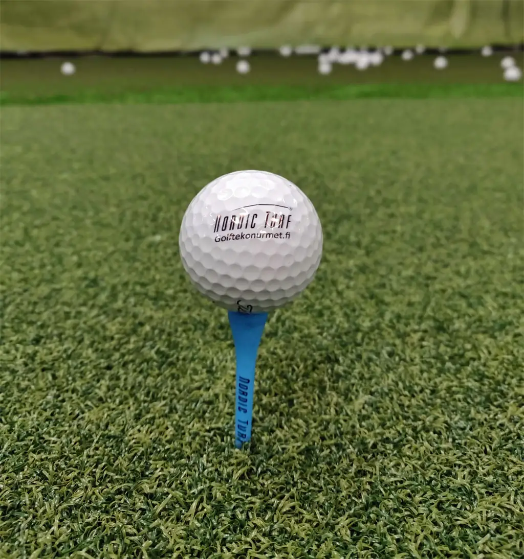 Golfpallo tavallisessa tiissä lyöntimatolla ilman reikää.