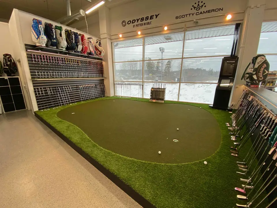 Puttiviheriö golfmyymälässä mailahyllyjen edessä.