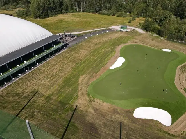 Ulkorangen kohdeviheriö ja kaksi valkoista hiekkaestettä ilmasta kuvattuna, vasemmalla hallikupla.