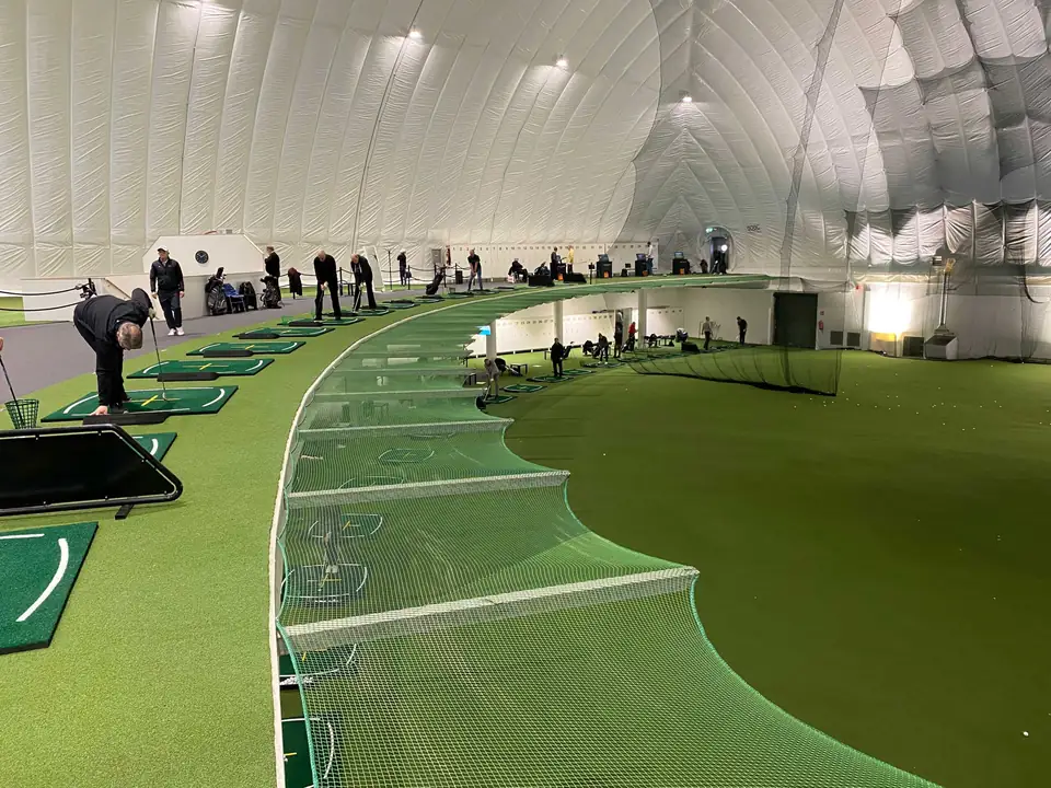 Season Golfin yläkerran lyöntipaikat ja kaareva viheriö kuplahallissa.