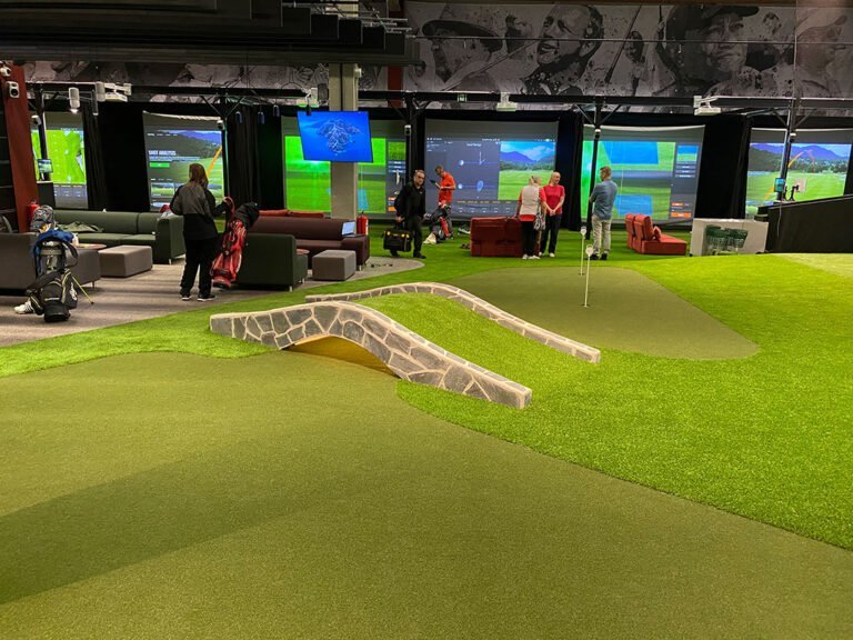 Viheriö ja kivisilta golfsimulaattorien edessä GoGolf Loungessa.