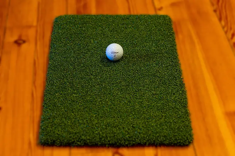 Golfpallo chippimatolla puulattialla.